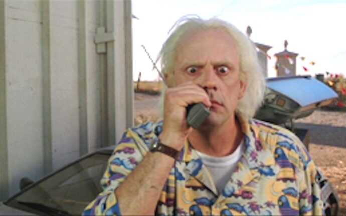 Doc Brown intenta aconsejar a distancia a su joven compañero de viaje en el tiempo Marty McFly (Regreso al Futuro II)